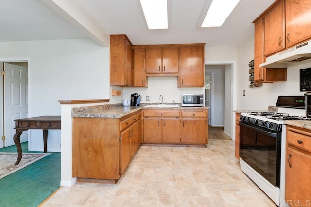 kitchen featuring white gas range, sink, and light carpet