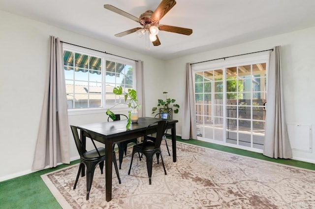 dining space featuring ceiling fan and light colored carpet