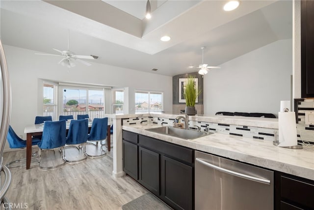 kitchen featuring sink, vaulted ceiling, decorative backsplash, and stainless steel dishwasher