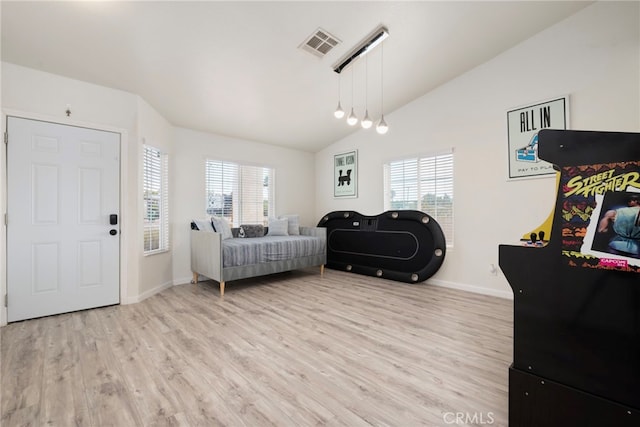 living room with light hardwood / wood-style floors and vaulted ceiling