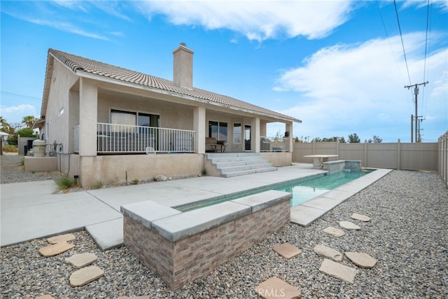 back of house featuring a fenced in pool and a patio