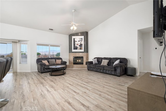 living room featuring light wood-type flooring, ceiling fan, and vaulted ceiling