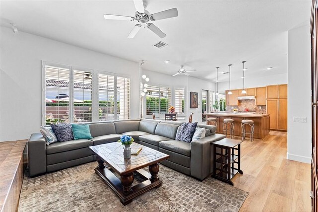 living room featuring ceiling fan and light wood-type flooring