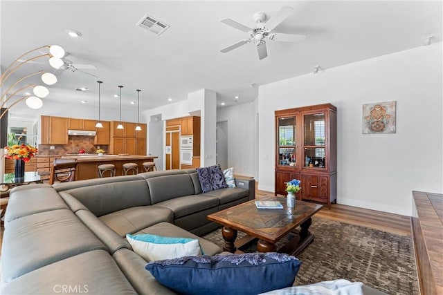 living room featuring hardwood / wood-style flooring and ceiling fan