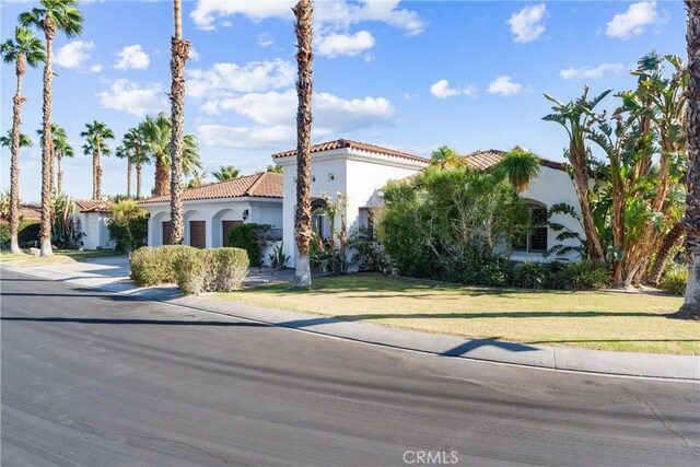 mediterranean / spanish-style home with a front yard