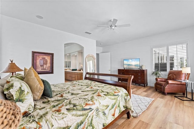 bedroom with ensuite bathroom, ceiling fan, and light wood-type flooring