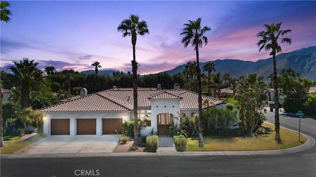 mediterranean / spanish-style home with a garage and a mountain view