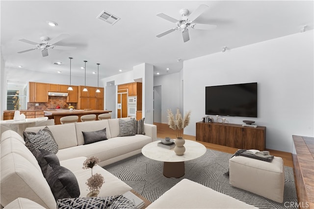 living room featuring ceiling fan and light hardwood / wood-style flooring