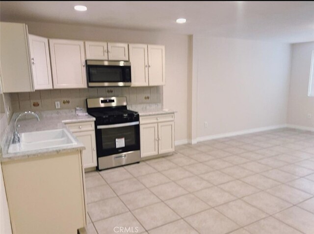 kitchen with white cabinets, stainless steel appliances, backsplash, and sink