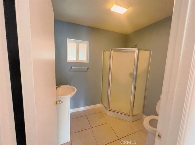 bathroom featuring tile patterned flooring, a shower with shower door, vanity, and toilet