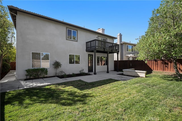 back of house featuring a patio area, a lawn, and a balcony