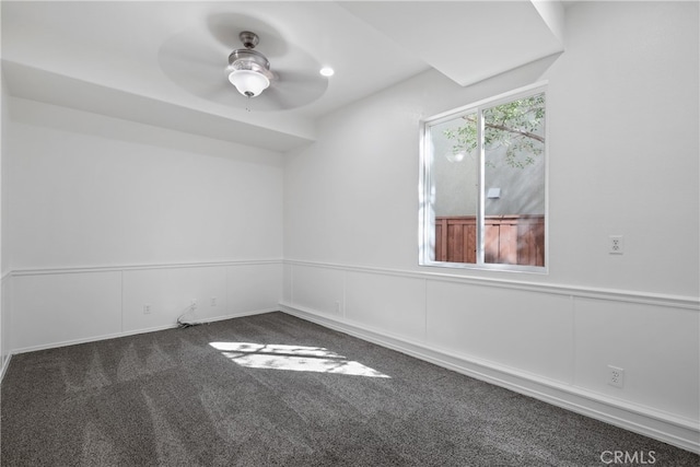 spare room with dark carpet and ceiling fan