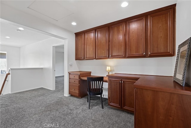 carpeted office space featuring built in desk