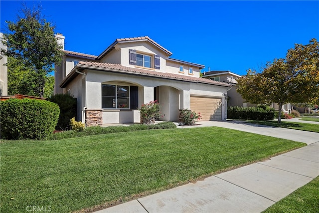 mediterranean / spanish-style house featuring a front yard and a garage