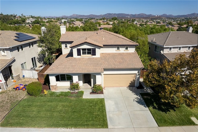 view of front of house with a mountain view, a front lawn, and a garage