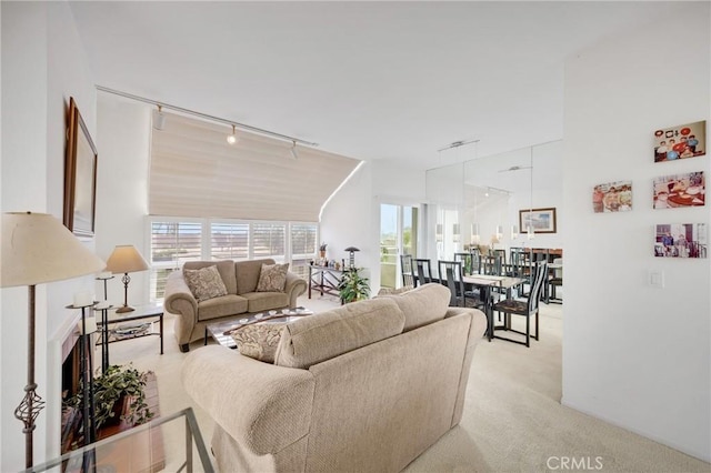 living room with rail lighting and light colored carpet