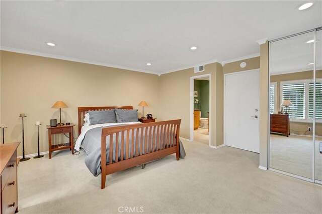 bedroom featuring ensuite bathroom, crown molding, and light carpet