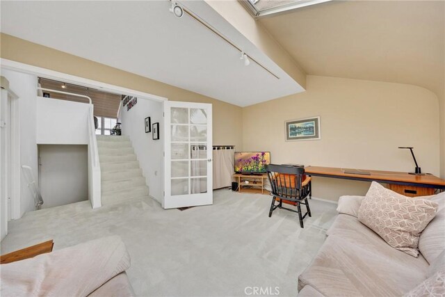 carpeted home office featuring rail lighting and vaulted ceiling