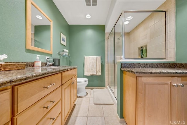 bathroom with tile patterned flooring, vanity, toilet, and a shower with door