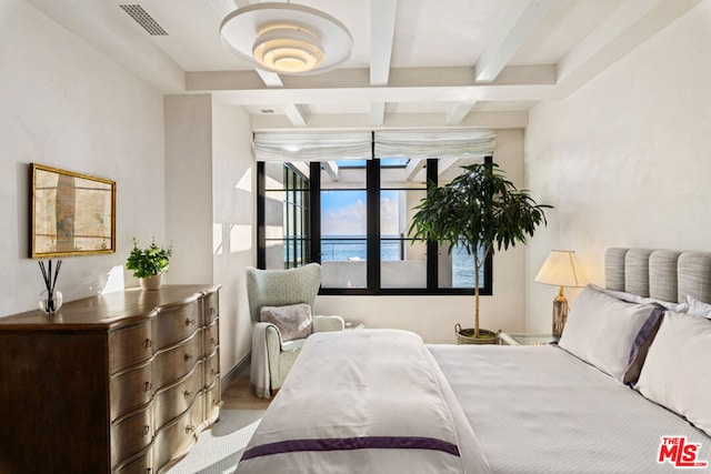 bedroom with a water view and beam ceiling