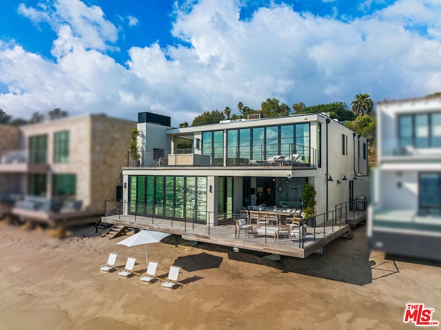 back of property featuring a deck and a balcony