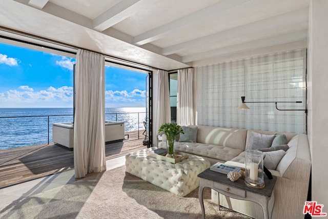 living room with beamed ceiling, light hardwood / wood-style floors, and a water view