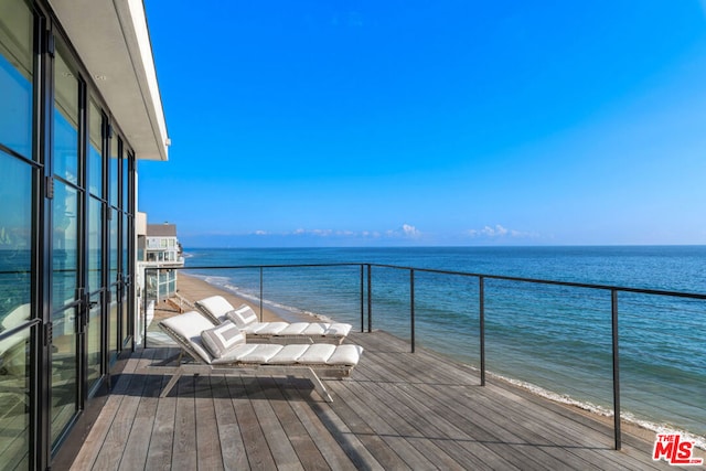 balcony featuring a beach view and a water view