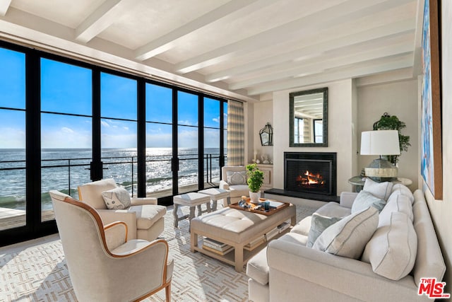 living room featuring a water view and beamed ceiling