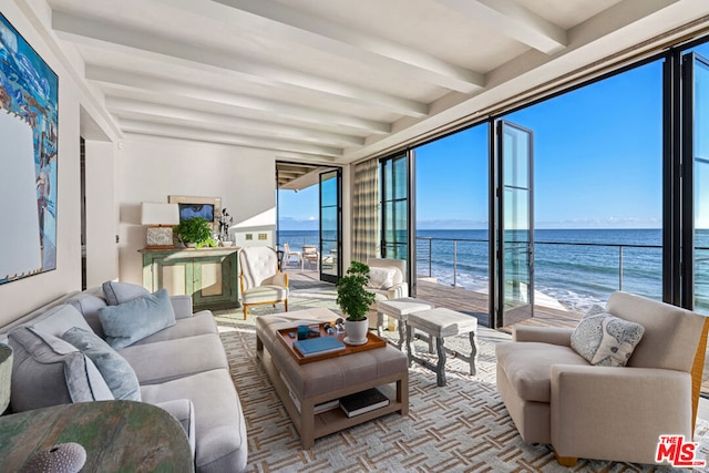 living room with a water view, beamed ceiling, and a beach view