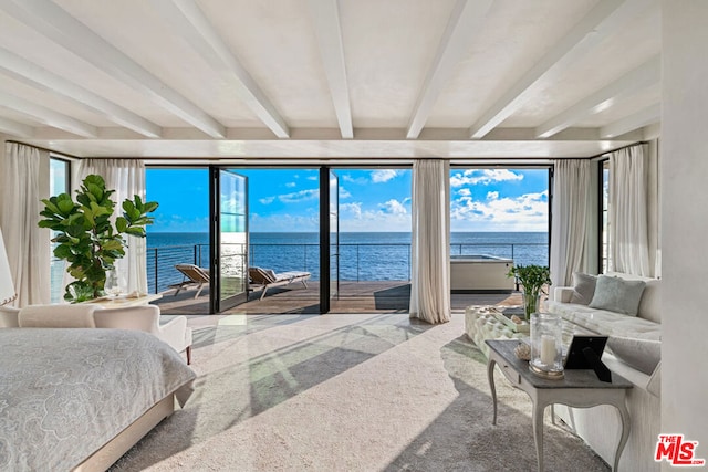 bedroom with a water view, beamed ceiling, and carpet