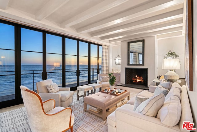 living room featuring a water view and beamed ceiling