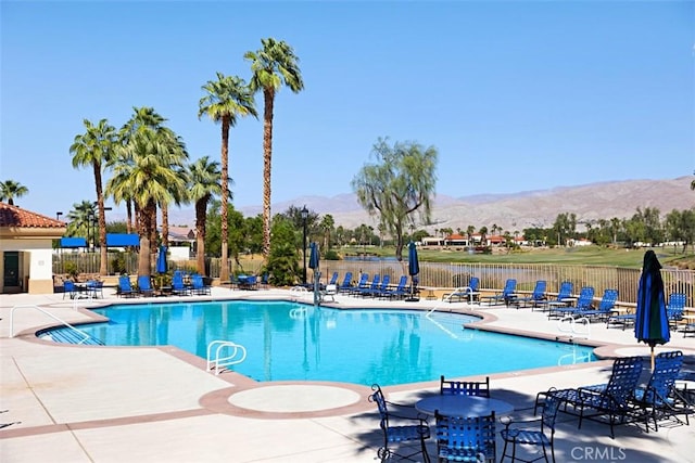 view of swimming pool with a patio area and a mountain view