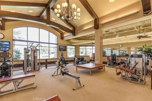 gym with carpet, ceiling fan with notable chandelier, and high vaulted ceiling