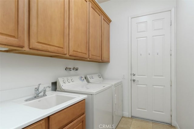 washroom with washer and clothes dryer, sink, light tile patterned floors, and cabinets