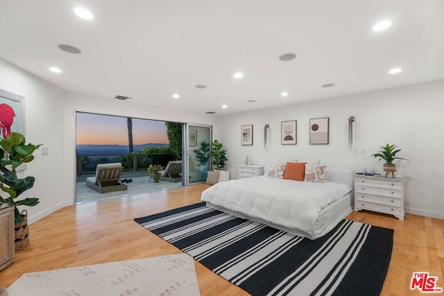 bedroom with access to exterior and light wood-type flooring