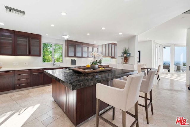 kitchen featuring a breakfast bar, a kitchen island, and sink