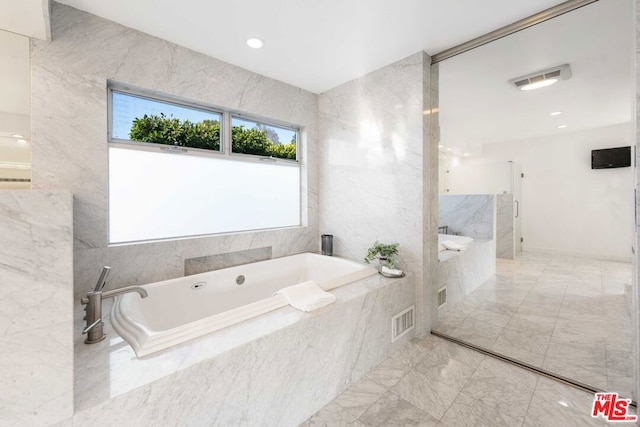 bathroom featuring plus walk in shower and tile walls