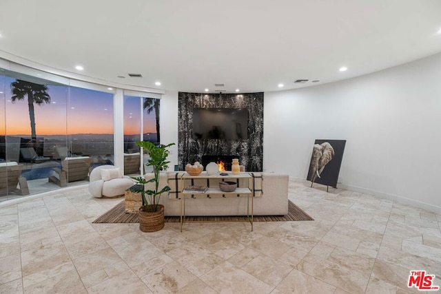 living room featuring floor to ceiling windows and a high end fireplace