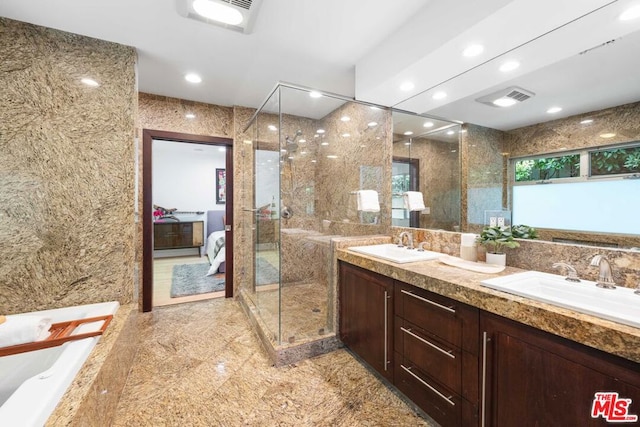 bathroom featuring vanity, tiled shower, and tile walls