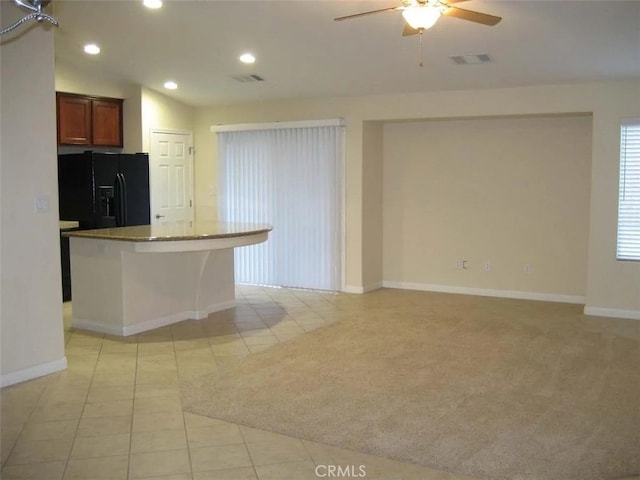 kitchen with ceiling fan, light carpet, black fridge, lofted ceiling, and a center island