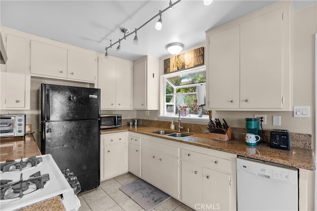 kitchen with light tile patterned flooring, white appliances, dark stone counters, sink, and white cabinetry