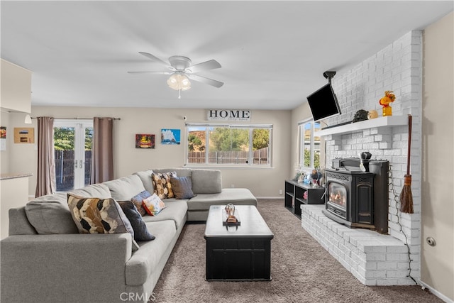 living room with a wood stove, ceiling fan, and carpet