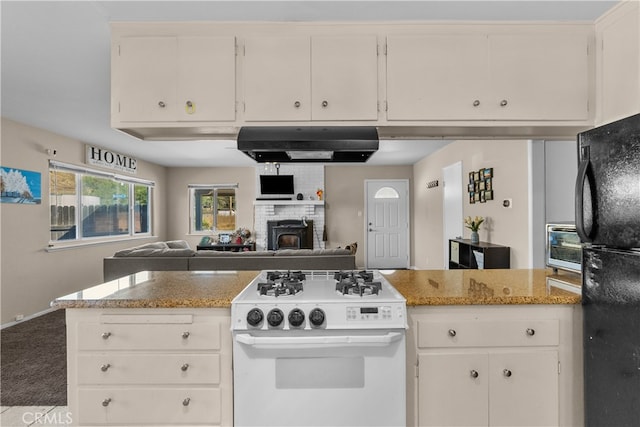 kitchen with white range with electric stovetop, light stone counters, white cabinetry, and black refrigerator