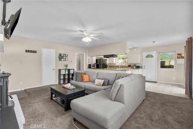 carpeted living room with ceiling fan