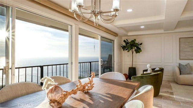 dining room with coffered ceiling, a water view, beamed ceiling, and a chandelier