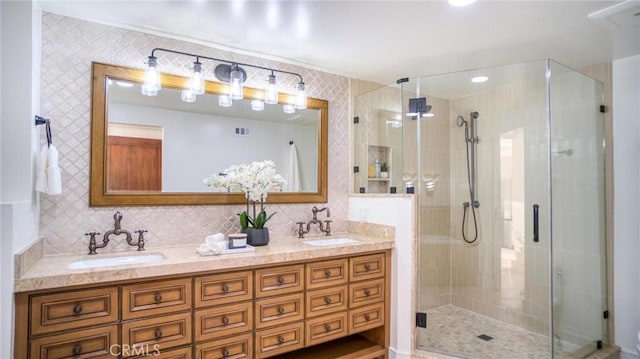 bathroom with backsplash, a shower with door, and vanity