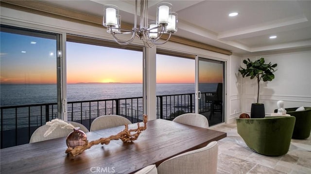 dining room with a water view and an inviting chandelier