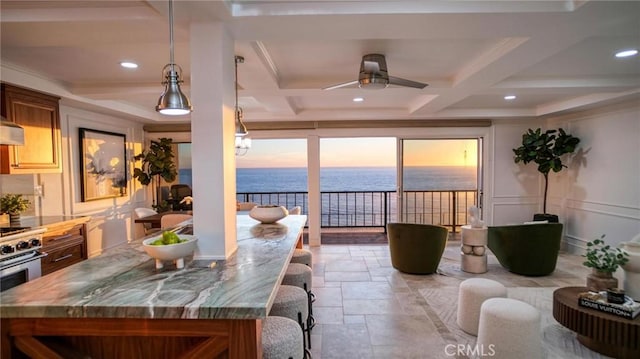 dining area with ceiling fan, coffered ceiling, beamed ceiling, crown molding, and a water view