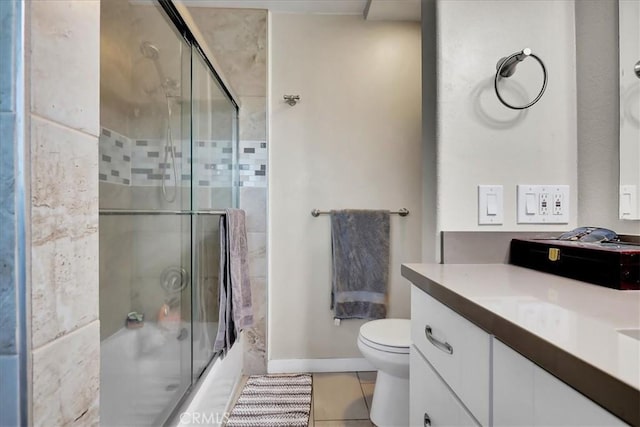 full bathroom with tile patterned floors, toilet, combined bath / shower with glass door, and vanity