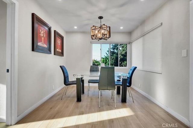 dining area featuring an inviting chandelier and light hardwood / wood-style flooring